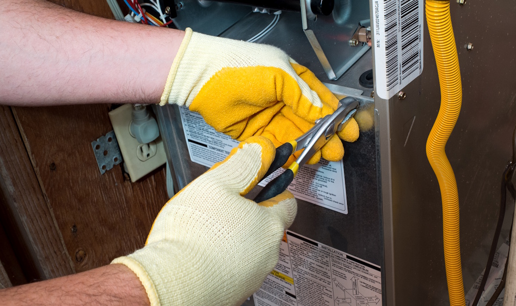 hvac technician repairing furnace